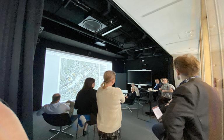 Raati katsoo kuvia valkokankaalta.