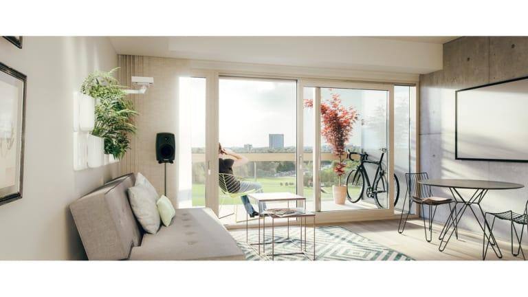 Asunnon olohuone ja iso terassi, johon laitettu polkupyörä ja kasvi.